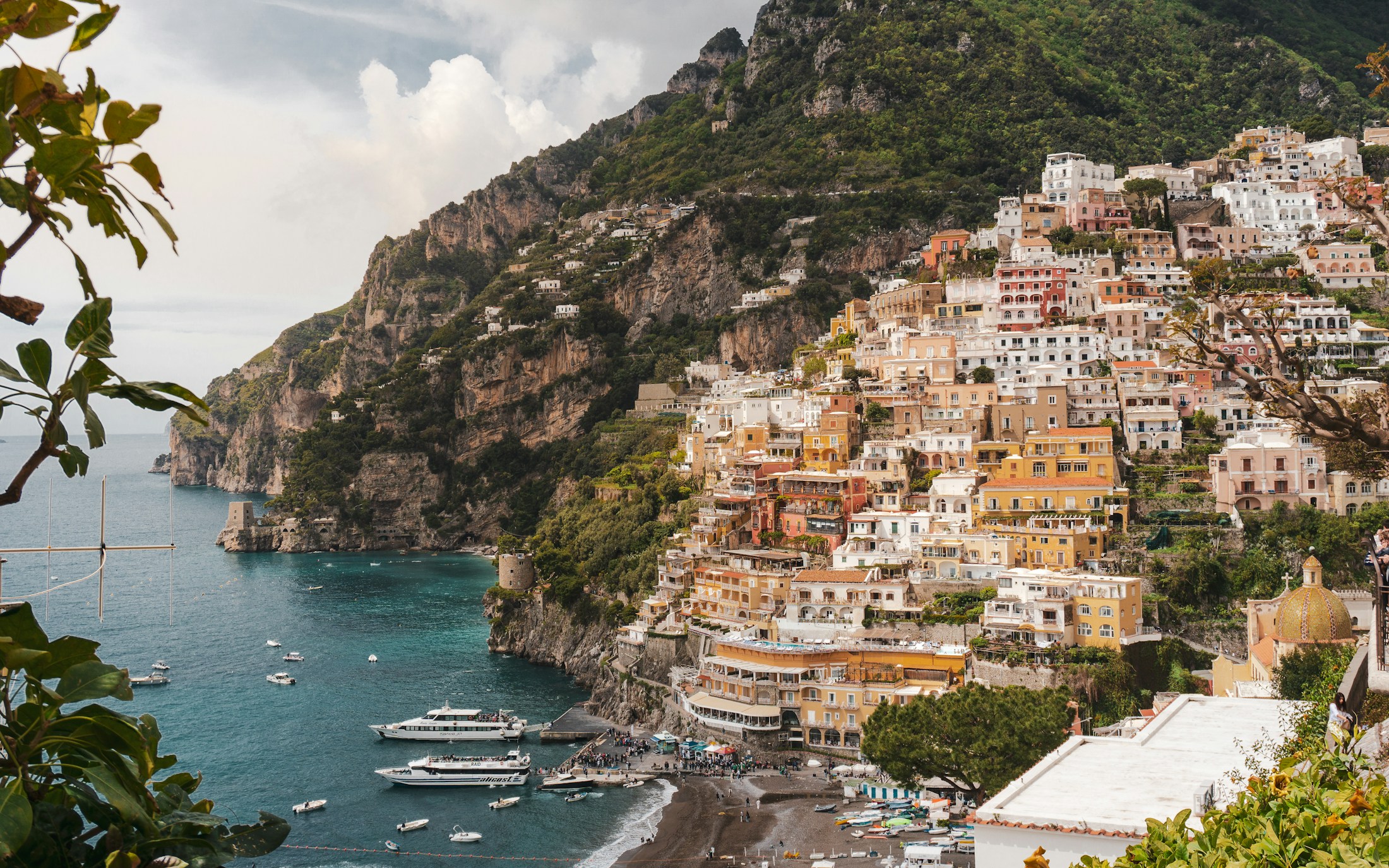 Pastel houses climbing the cliffs above the sea at Positano, Italy